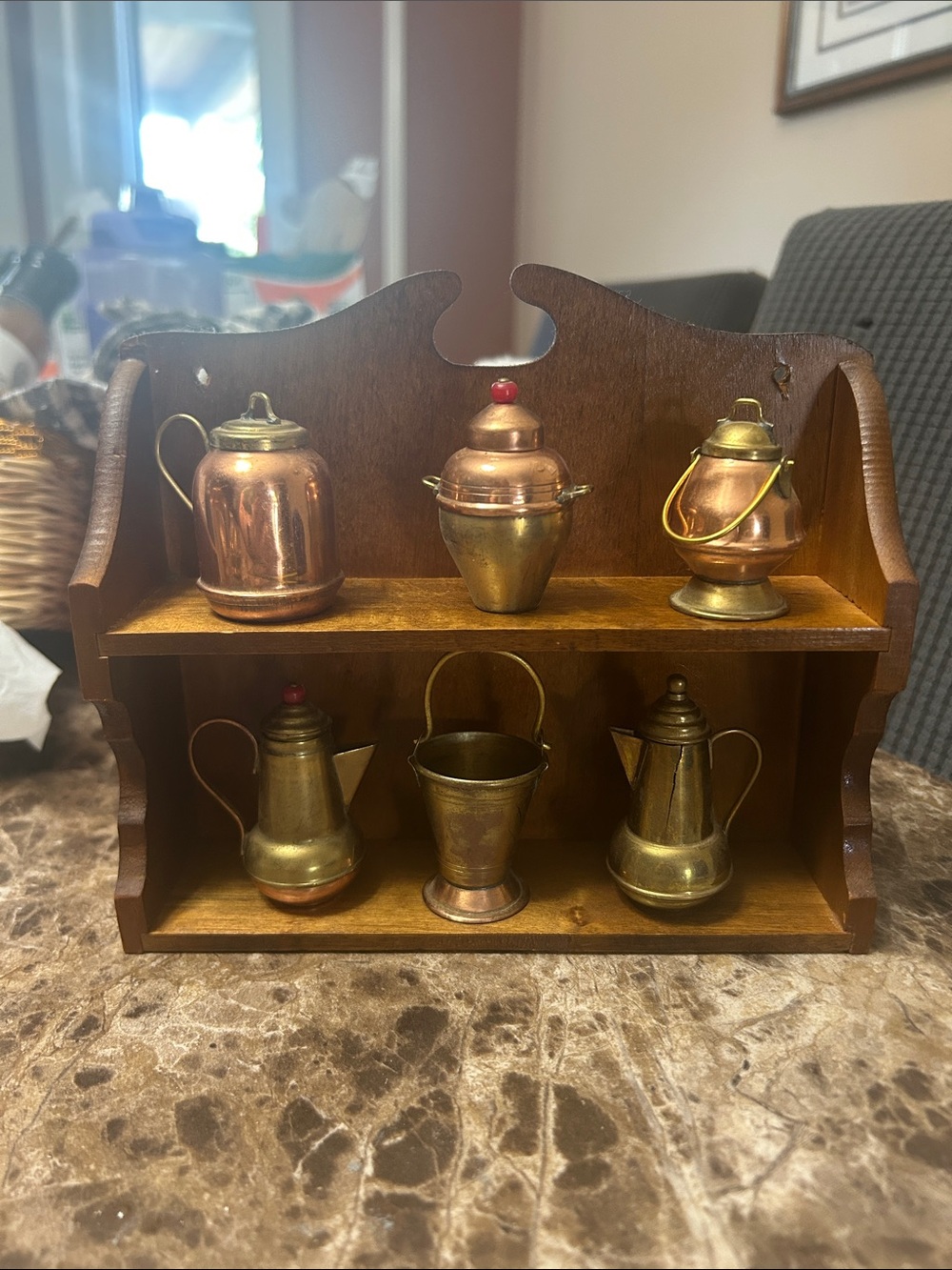 Vintage miniature copper, brass, and tin kitchenware set on a wooden shelf